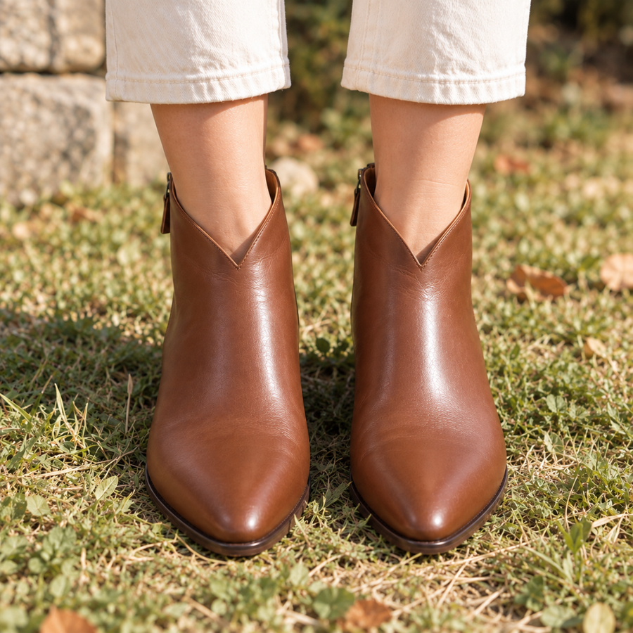 Bottines femme marron échancrées en V, vue de face portées dans l'herbe