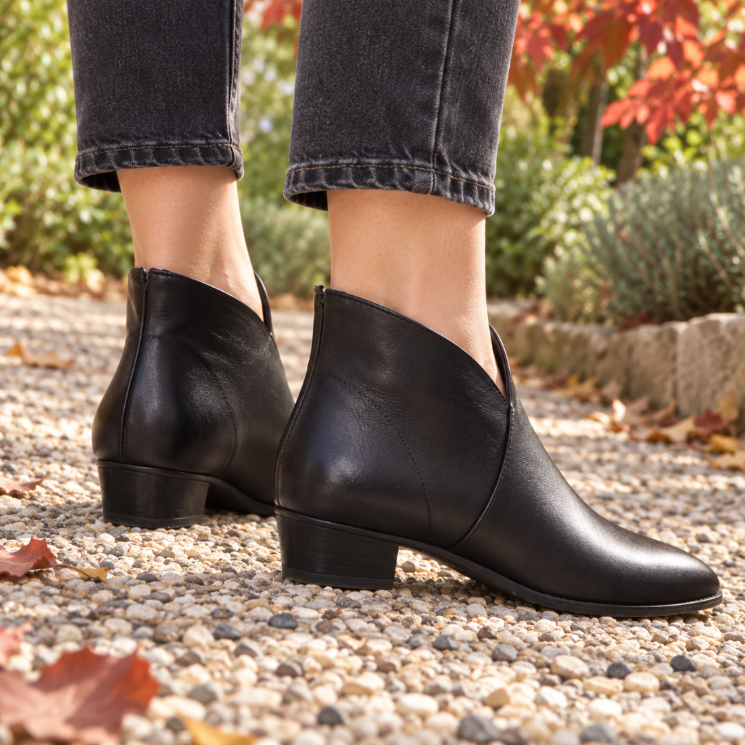 Bottines noires vues de trois quarts arrière, talon bloc bas sur gravier