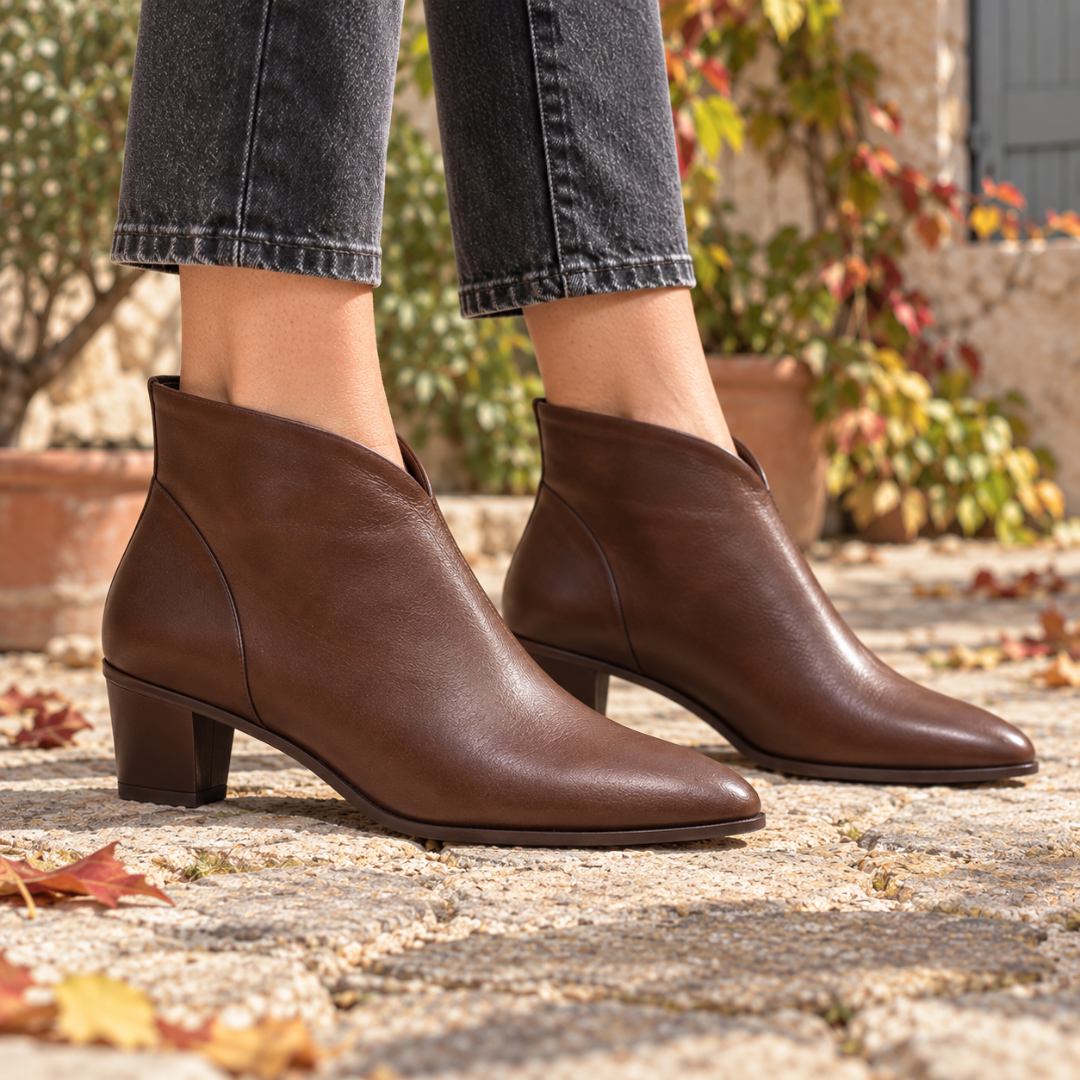 Bottines marron à décolleté en V et talon bloc portées avec un pantalon gris