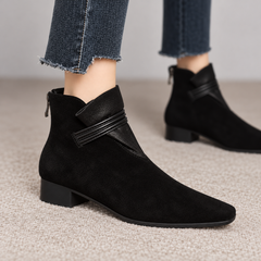 Bottine noire à petit talon bloc portée avec un pantalon brut effiloché