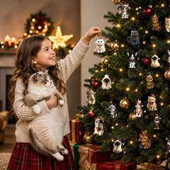 Enfant accrochant un ornement chat du calendrier de l'Avent au sapin de Noël