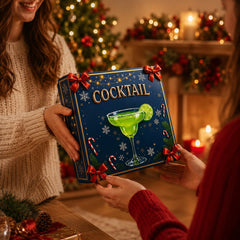 Coffret calendrier de l'Avent cocktails offert en cadeau devant un sapin décoré