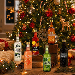 Six suspensions bouteilles de cocktails posées devant un sapin illuminé