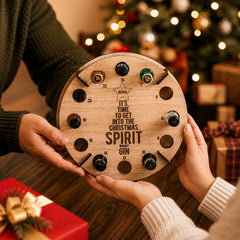 Deux mains tenant le calendrier de l'Avent rond en bois gravé avec mini-bouteilles