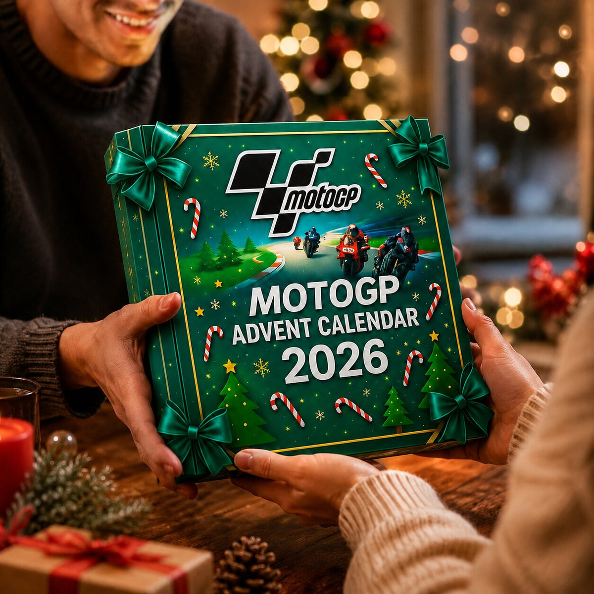 Deux mains tenant le calendrier de l'Avent MotoGP 2026 au décor de circuit