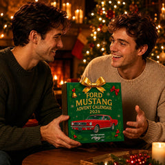Deux hommes tenant le calendrier de l'Avent Mustang 2026 devant un sapin illuminé
