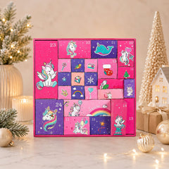 Calendrier de l'Avent licorne posé sur un plan de marbre avec décorations dorées