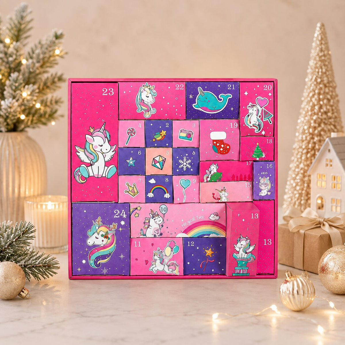 Calendrier de l'Avent licorne posé sur un plan de marbre avec décorations dorées