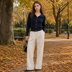 Cardigan bleu marine boutonné devant, col polo et boutons dorés, dans un parc doré