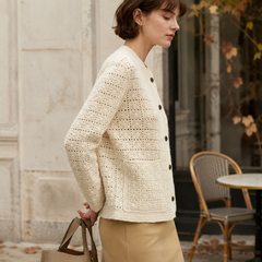 Vue de profil du cardigan beige, boutons foncés contrastants et maille ajourée en relief