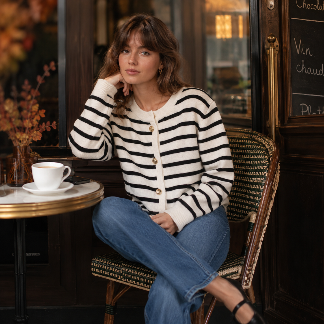 Cardigan rayé noir porté par une femme attablée à une terrasse parisienne