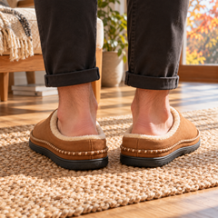 Vue arrière des chaussons homme brun à talon ouvert sur tapis tressé
