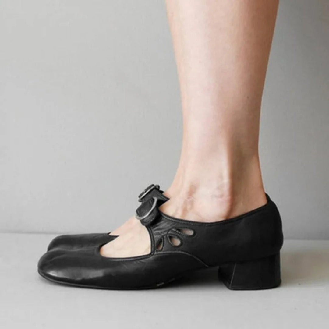 Chaussure femme noire à bride et talon bas, portée de côté avec détails ajourés