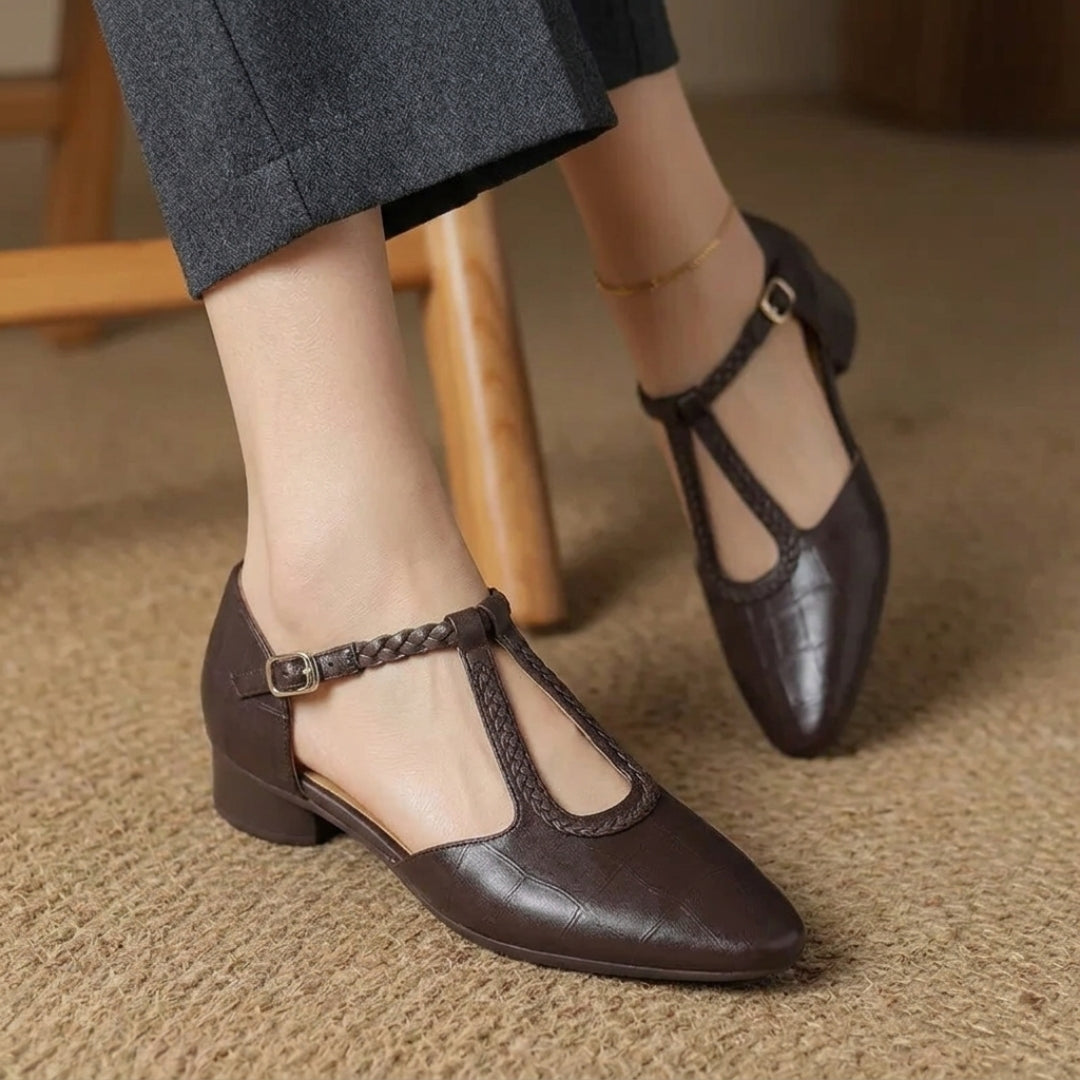 Chaussure plate marron bride en T posée sur le côté, vue de profil rapprochée