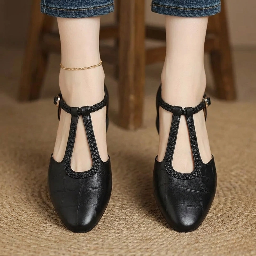 Chaussures plates bride en T cuir texturé noir portées avec un jean, vue de face