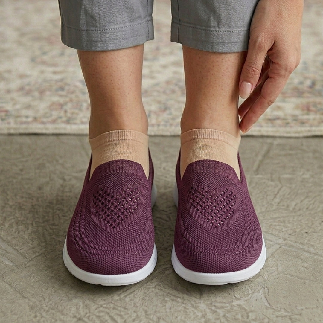 Femme enfilant une chaussure slip-on mauve, vue rapprochée du pied