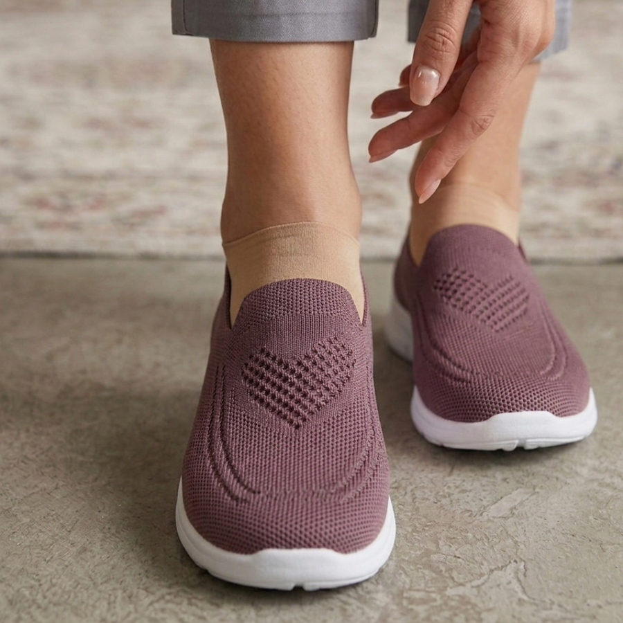 Femme portant des chaussures slip-on roses en maille avec motif cœur ajouré