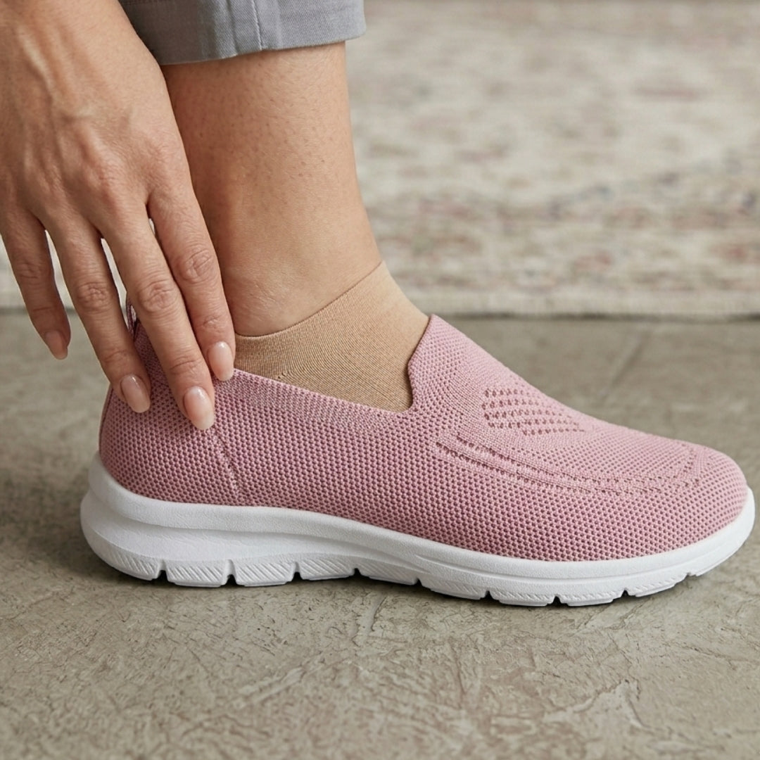 Femme enfilant une chaussure slip-on rose légère, vue rapprochée