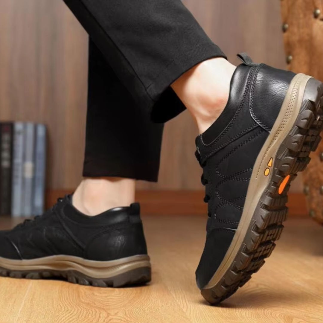 Chaussure homme noire soulevée dévoilant la semelle crantée à détails orange