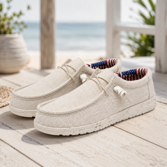 Paire de chaussures homme blanches posées sur terrasse en bois, doublure imprimée visible