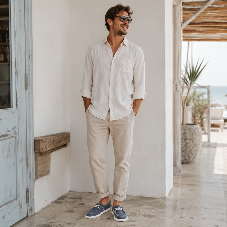 Homme portant des chaussures slip-on bleues et un ensemble beige sur une terrasse