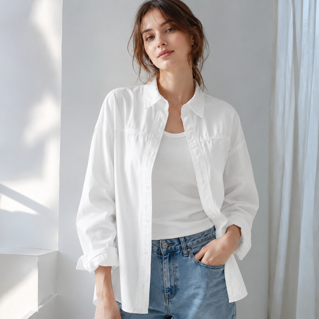 Chemise femme oversize blanche ouverte sur un débardeur et un pantalon bleu