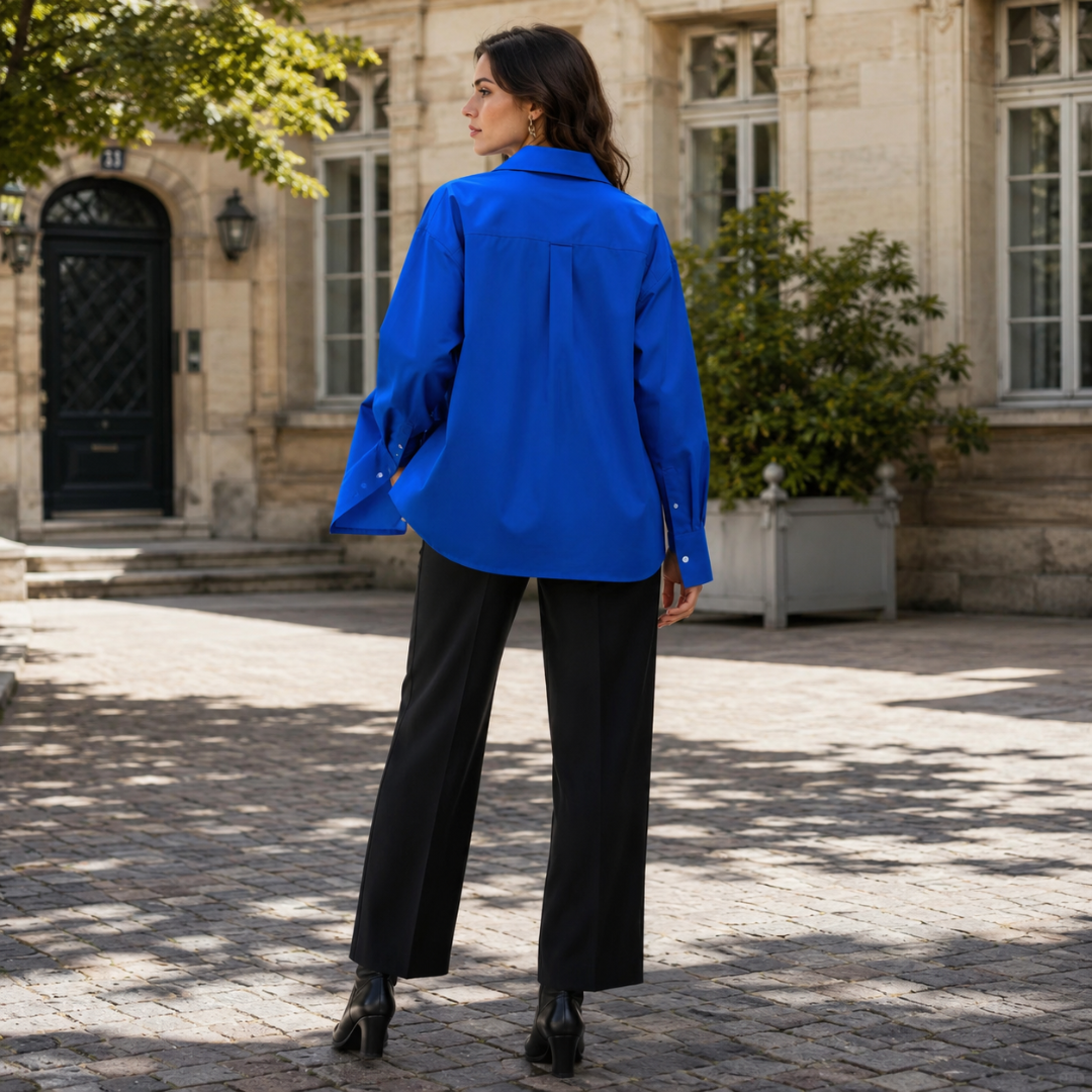Dos de la chemise bleue oversize avec pli central et bas arrondi allongé