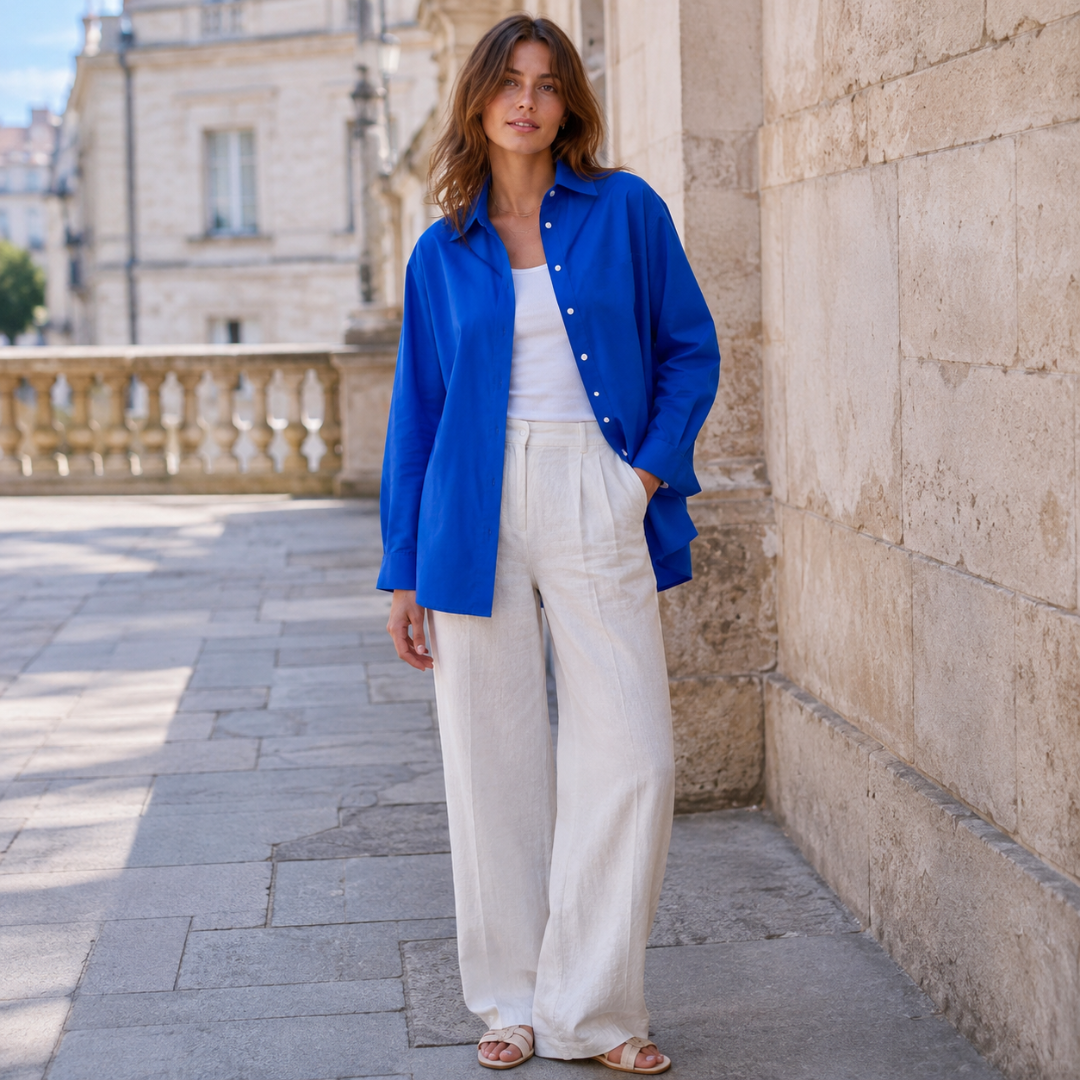 Chemise femme bleue au tombé fluide portée avec un pantalon large écru en ville