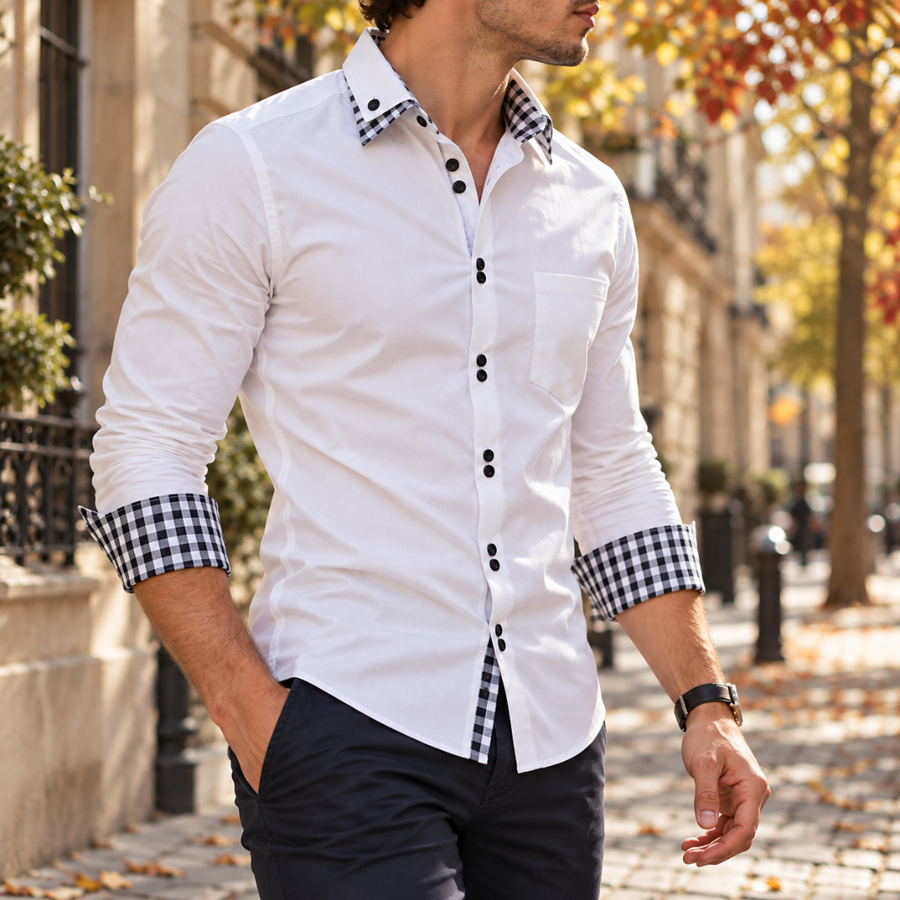Chemise blanche homme vue de trois quarts, manches retroussées révélant la doublure à carreaux