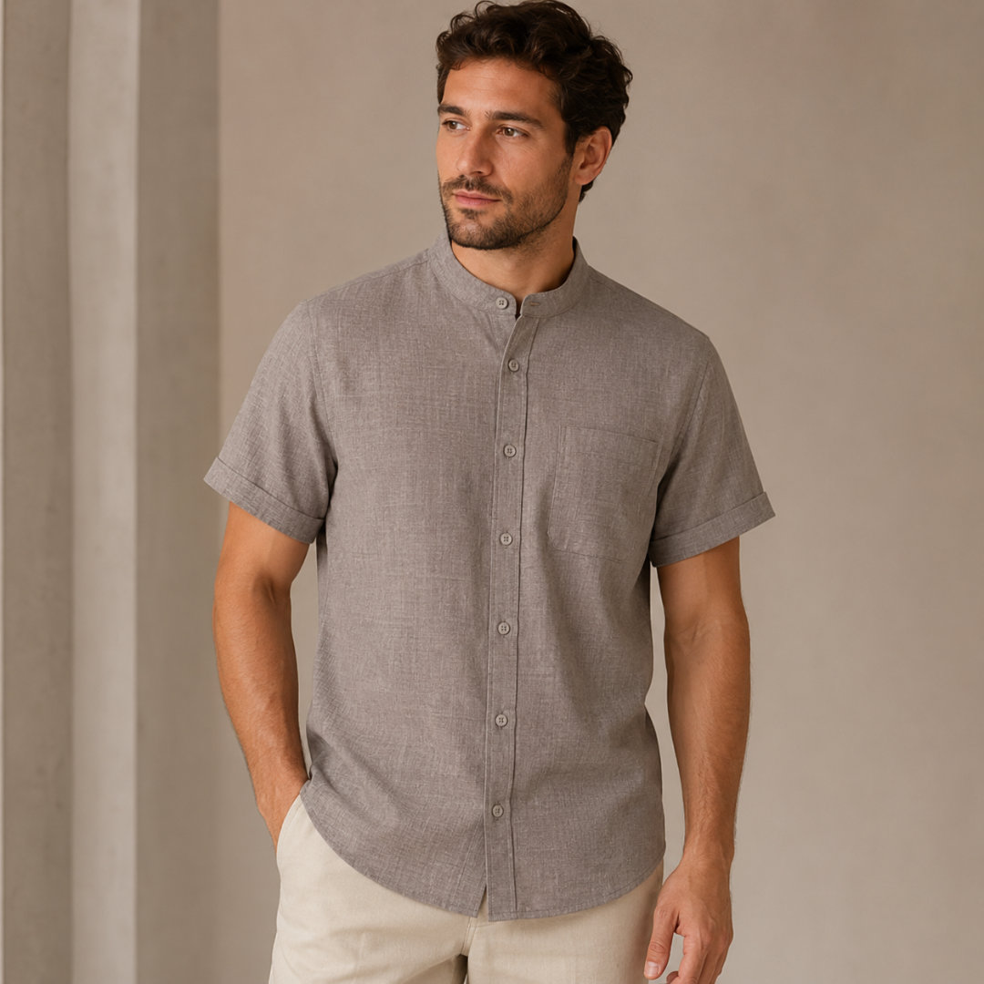 Homme portant la chemise grise, vue de face sur fond sombre