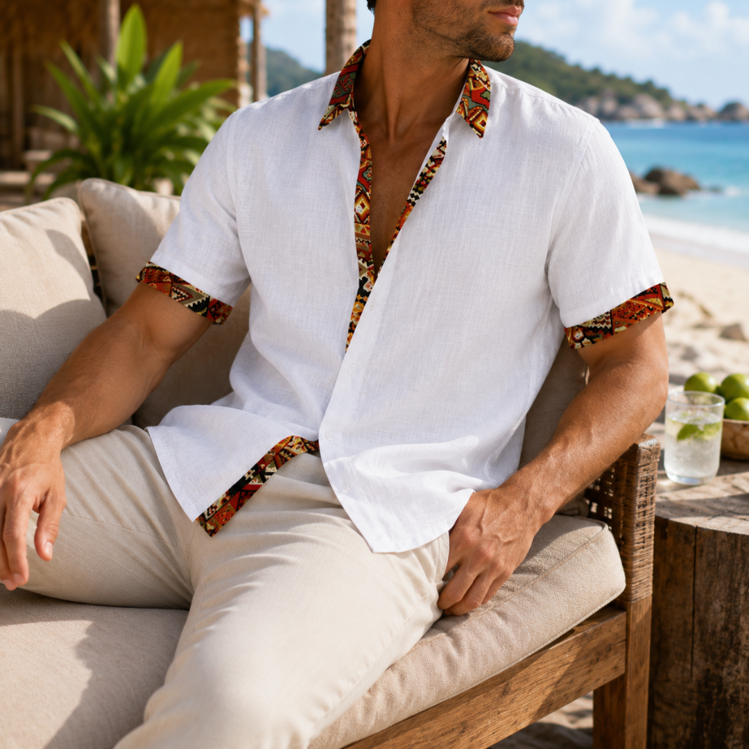 Chemise homme blanche portée assise, détails ethniques au col et aux poignets