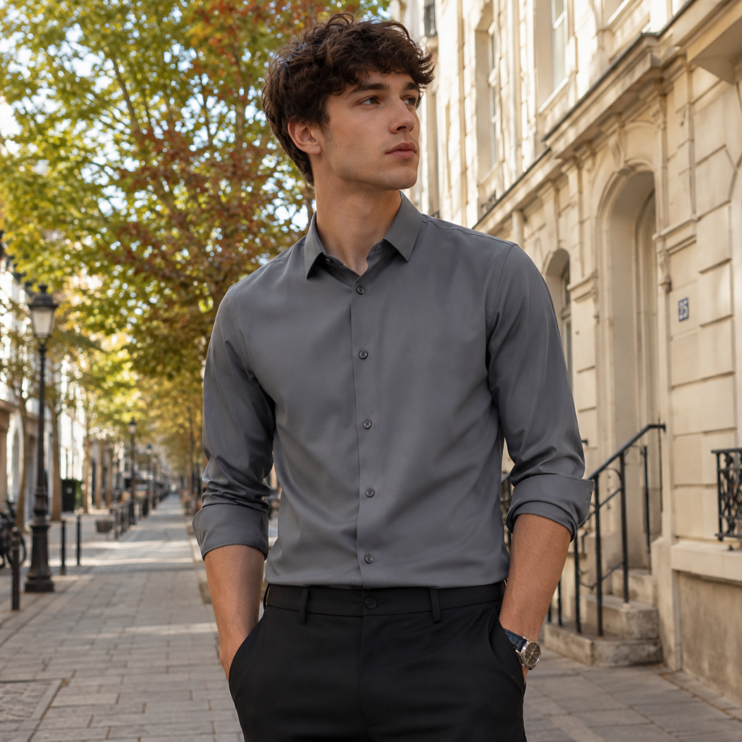 Chemise homme grise à manches longues retroussées, portée avec un pantalon noir en ville