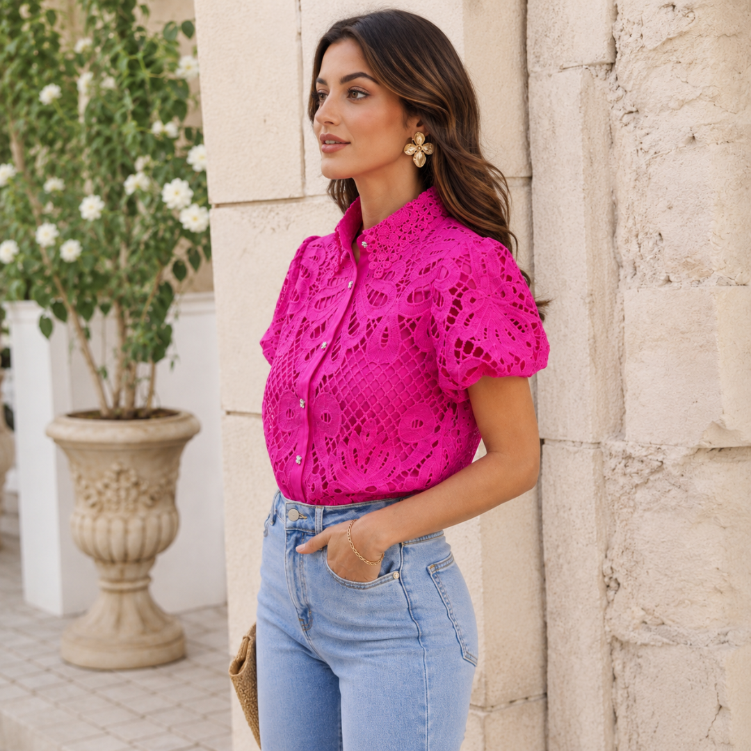 Chemisier rose vu de profil, manches courtes bouffantes et motifs découpés sur l'épaule