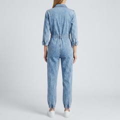 Combinaison denim femme vue de bas chevilles élastiquées et sneakers blanches