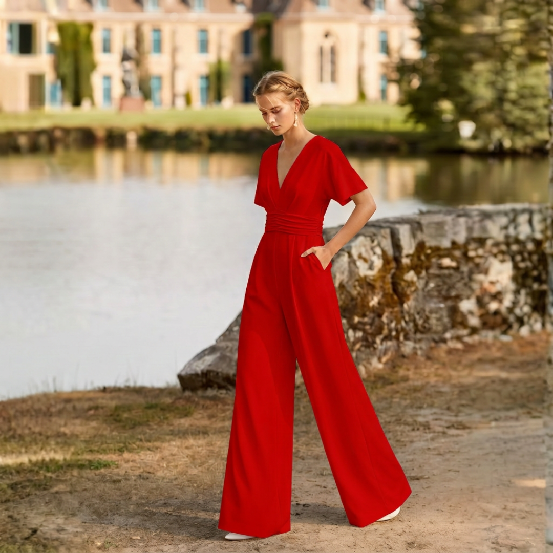 Combinaison rouge jambes larges col V portée dans un jardin