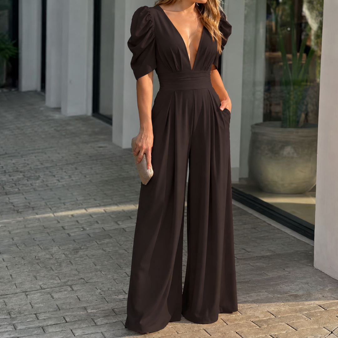 Combinaison longue noire col V profond, jambes fluides et pochette dorée