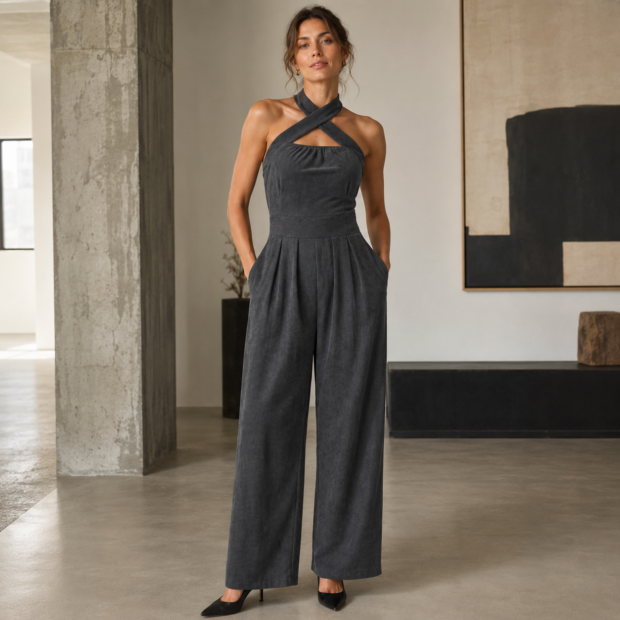 Combinaison femme gris assise dans un intérieur épuré