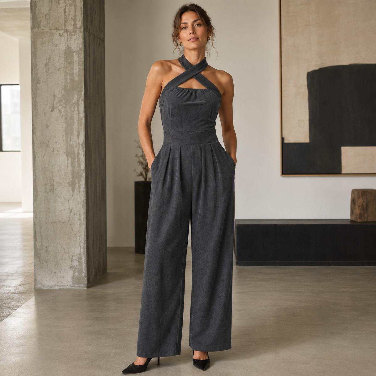 Combinaison femme gris assise dans un intérieur épuré