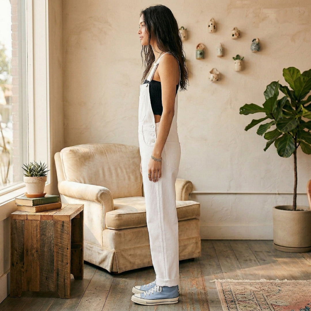 Vue de dos, debout, bras le long du corps, salopette blanche décontractée