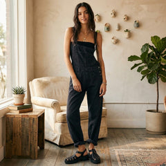 Vue de face, debout, combinaison salopette noire, allure élégante et casual
