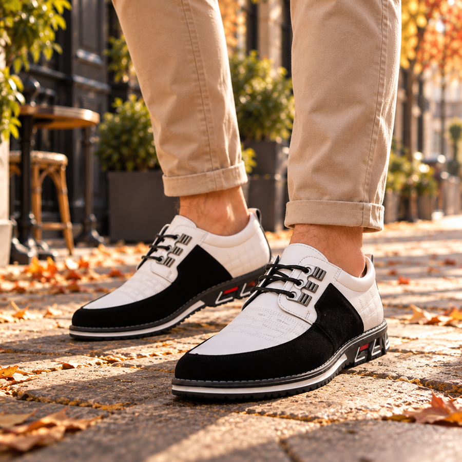 Derbies homme blanc et noir portés avec un chino beige, lacets noirs et passants métalliques