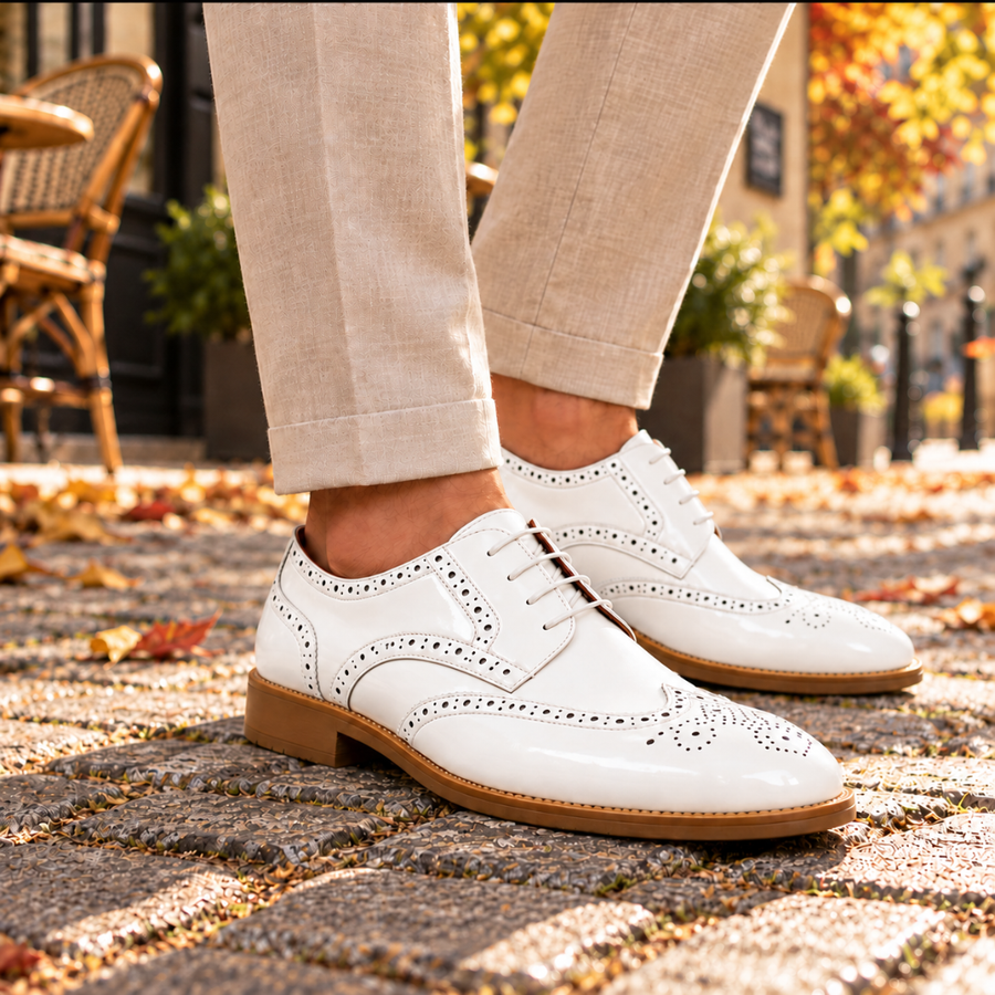Derbies homme blancs vus de trois quarts, bout fleuri perforé et semelle claire