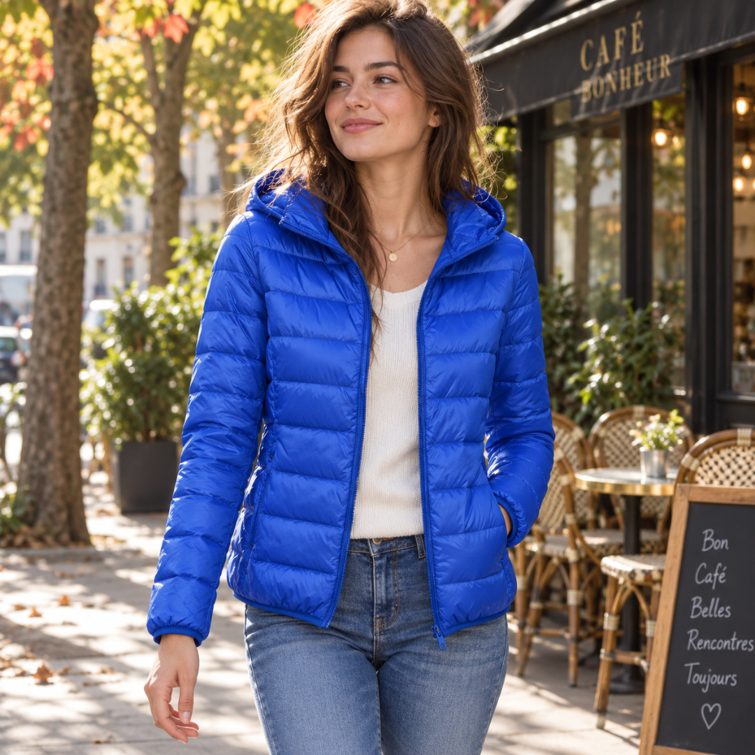 Doudoune femme bleu vif à capuche portée ouverte devant un café