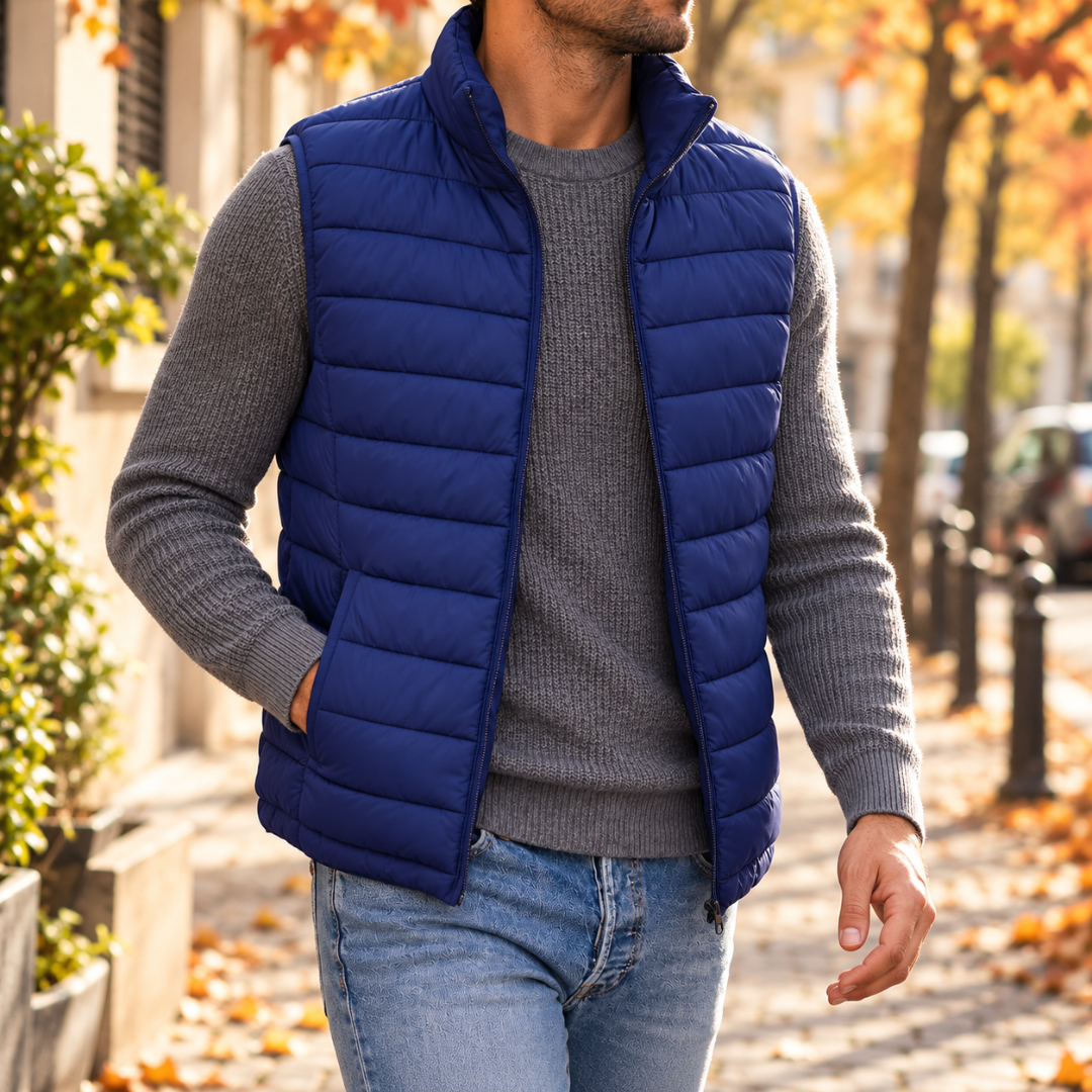 Homme en doudoune sans manches bleue ouverte, col montant et poches latérales, pantalon clair