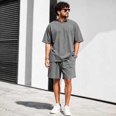 Homme portant un ensemble gris foncé t-shirt oversize et short d'été