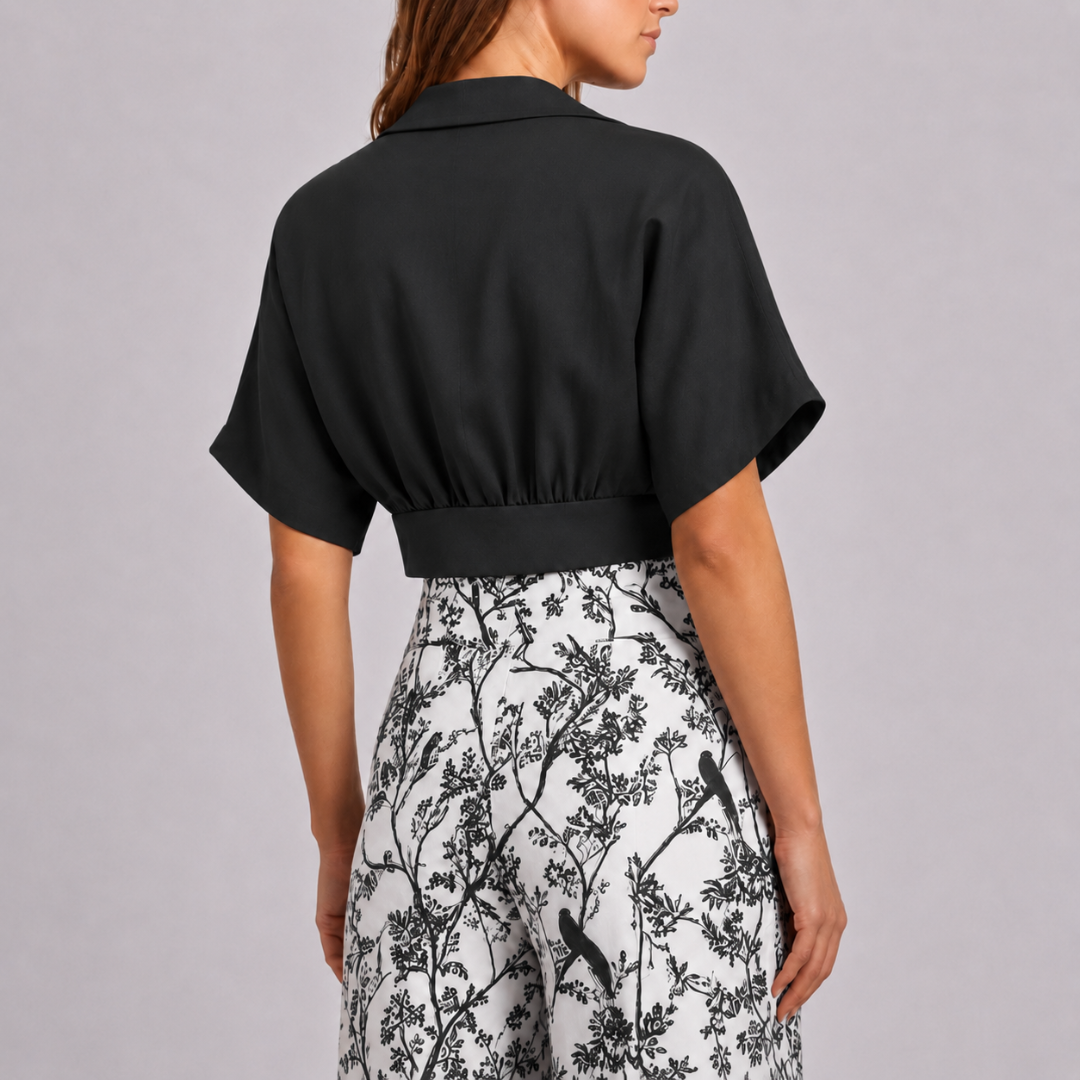 Dos du top court noir sur pantalon large à motif floral contrasté
