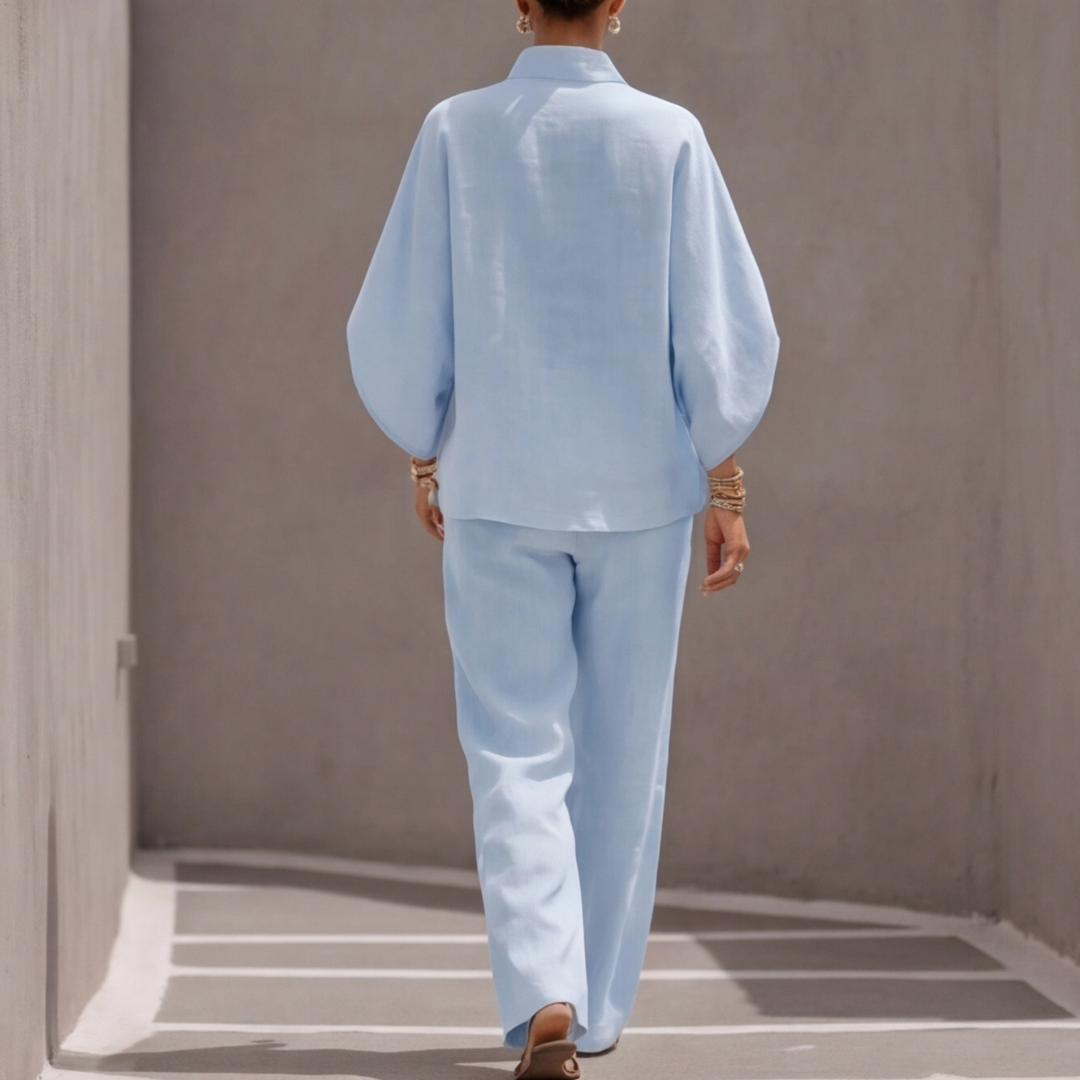 Ensemble bleu clair porté en pied, pantalon large et blouse col montant boutonnée