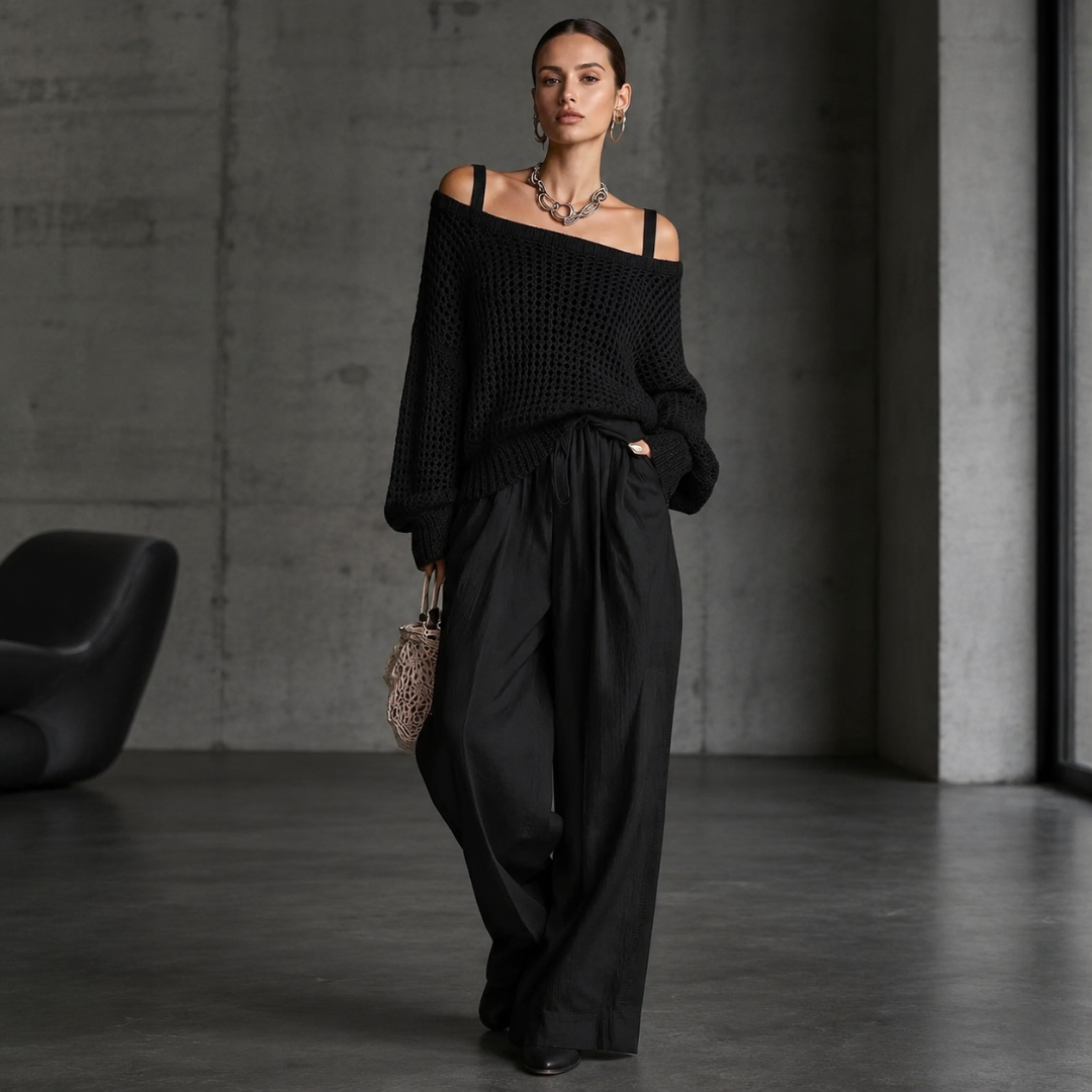 Pull noir en maille ajourée à épaules dénudées porté en gros plan