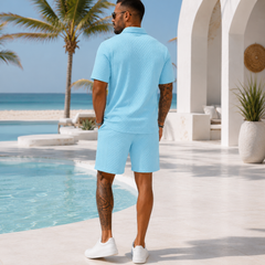 Ensemble homme bleu clair en mouvement, polo texturé et short assorti, cadre tropical