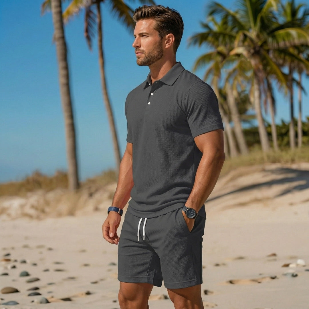 Ensemble homme polo gris foncé et short à cordon blanc parmi les palmiers